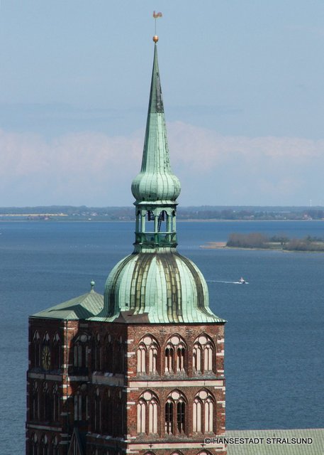 Die-Tuerme-der-Kirche-St.-Nikolai-mit-Strelasund-im-Hintergrund.JPG